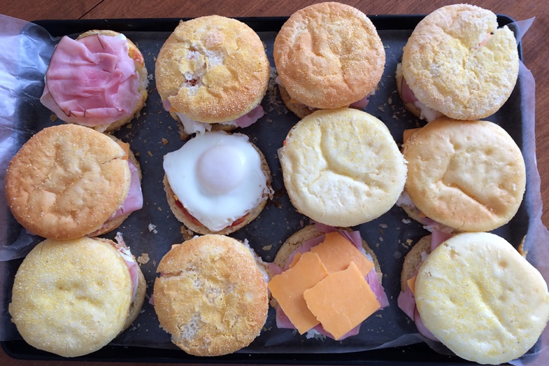 Photo of a tray of glutino gluten free english muffins showing the toppings in different stages of completion.